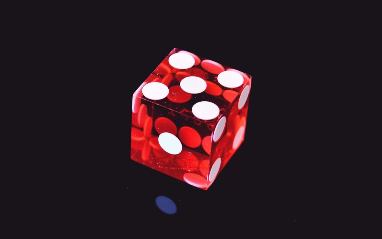 Crvena providna kockica na crnoj površini
