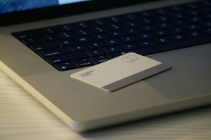 Kreditna kartica naslonjena na naslon za dlan računara pored osvetljene tastature